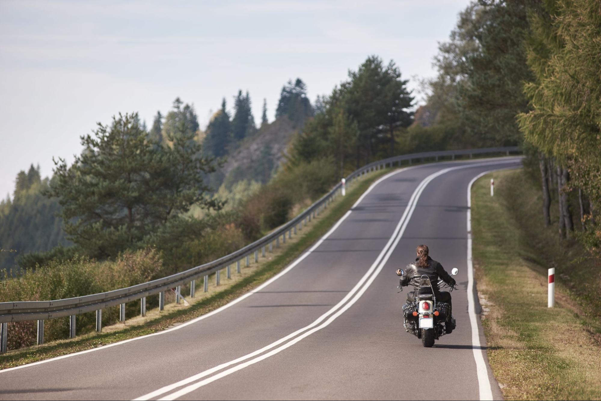 motocyklista zbliżający się do zakrętu na drodze